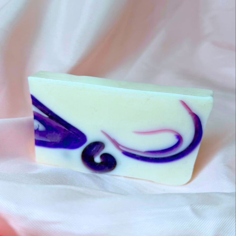A bar of Primal Elements glycerin Ariel soap. It is white with swirls of purple. 