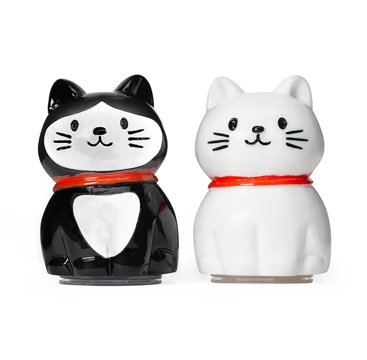two cat shaped lip balms in tuxedo and white 