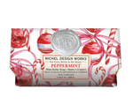 Michel Design Works Peppermint Shea Butter Soap in a festive red and white holiday-themed paper sleeve featuring ornaments, candy canes, and a silver wax seal.