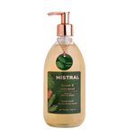 A glass bottle of Mistral hand wash with balsam and cedarwood scent, featuring a copper pump dispenser and a dark green label, shown on a white background.