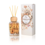 A reed diffuser bottle with a wooden cap and natural reeds stands next to its illustrated white box labeled 'Pumpkin Latte' on a clean white background.
