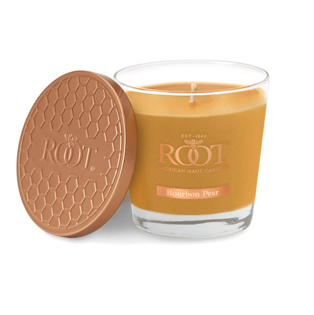 A Root American Made Candle in a clear glass jar with amber-colored wax, shown next to its textured round lid on a white background.