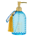 Blue bottle of lotus and shea butter hand wash with gold pump and tassel on a white background