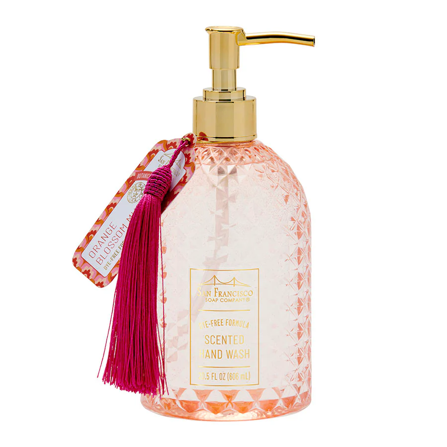 Botanical orange blossom scented hand wash bottle with gold pump and pink tassel on a white background