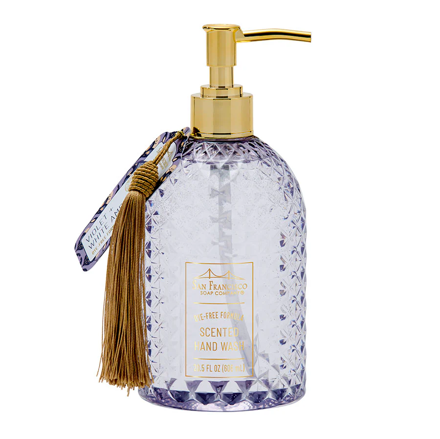 Decorative violet and amber scented hand soap bottle with gold pump and tassel on a white background