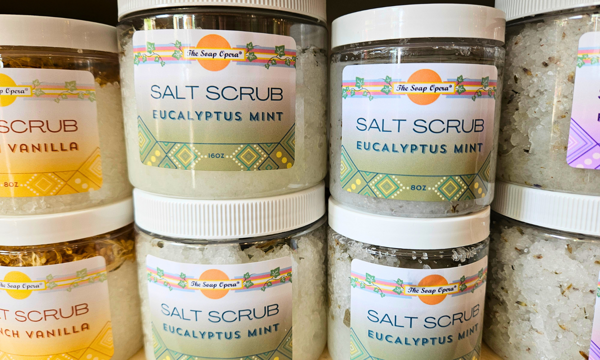 Multiple jars of salt scrub with visible labels on a surface.