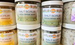 Multiple jars of salt scrub with visible labels on a surface.