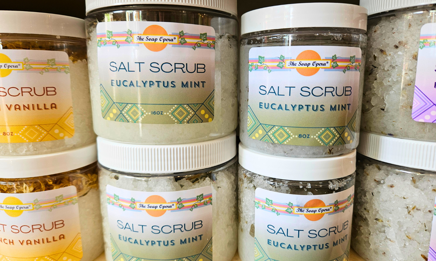 Multiple jars of salt scrub with visible labels on a surface.