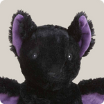 Black bat stuffed animal with purple ears and accents on a beige background