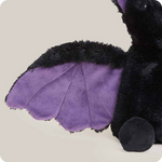 Black plush bat toy with purple wings on a beige background