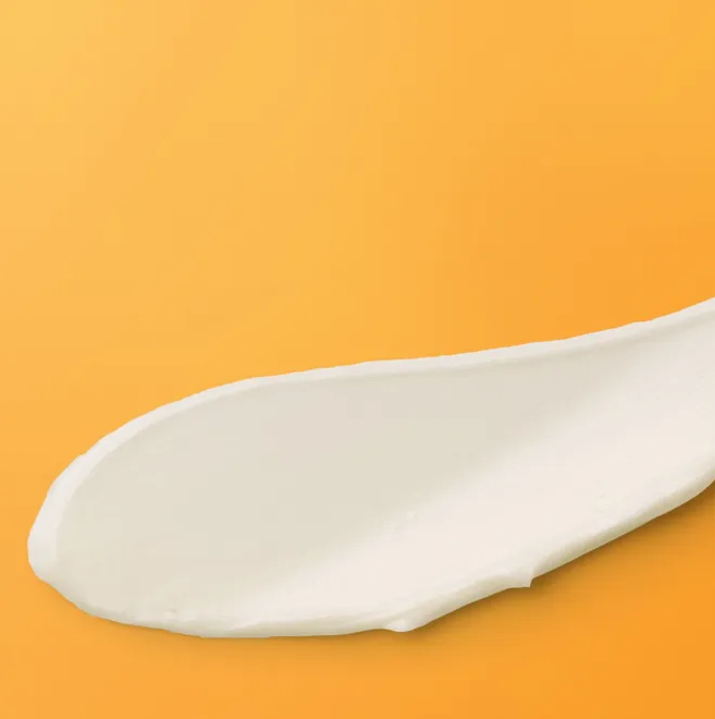 soap bark and chamomile deep cleansing cream smoothed on an orange background creamy texture