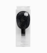 A package containing a Celavi "Pro Styling Brush / ROUND PADDLE BRUSH WITH MIRROR". "Reduce Static / Effective Detangling / Add Volume". Hair brush is black all over, except of the very tips of its bristles, which are white.