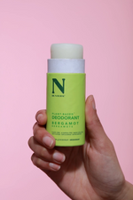 hand holding open light green deodorant stick plastic free packaging zero waste deodorant bergamot scented deodorant