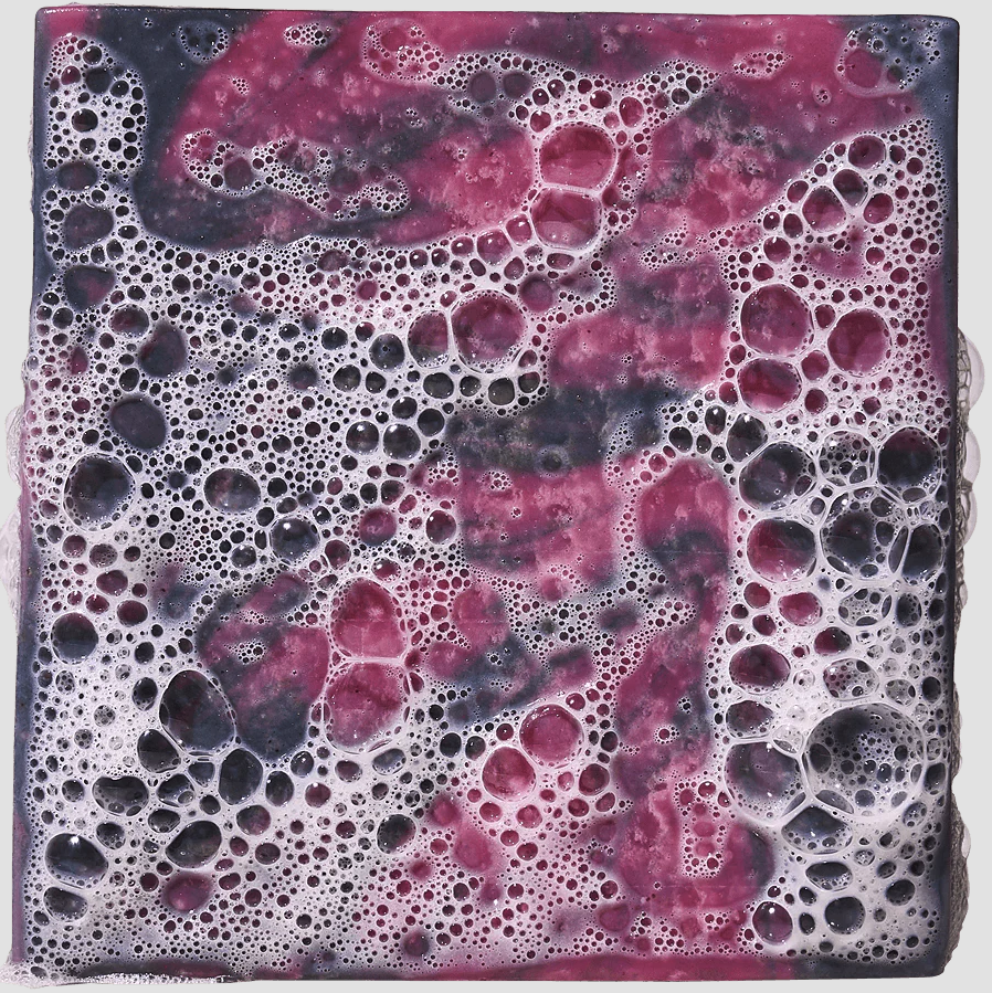 Heavy grit soap with a marbled design of pink, purple, and black colors