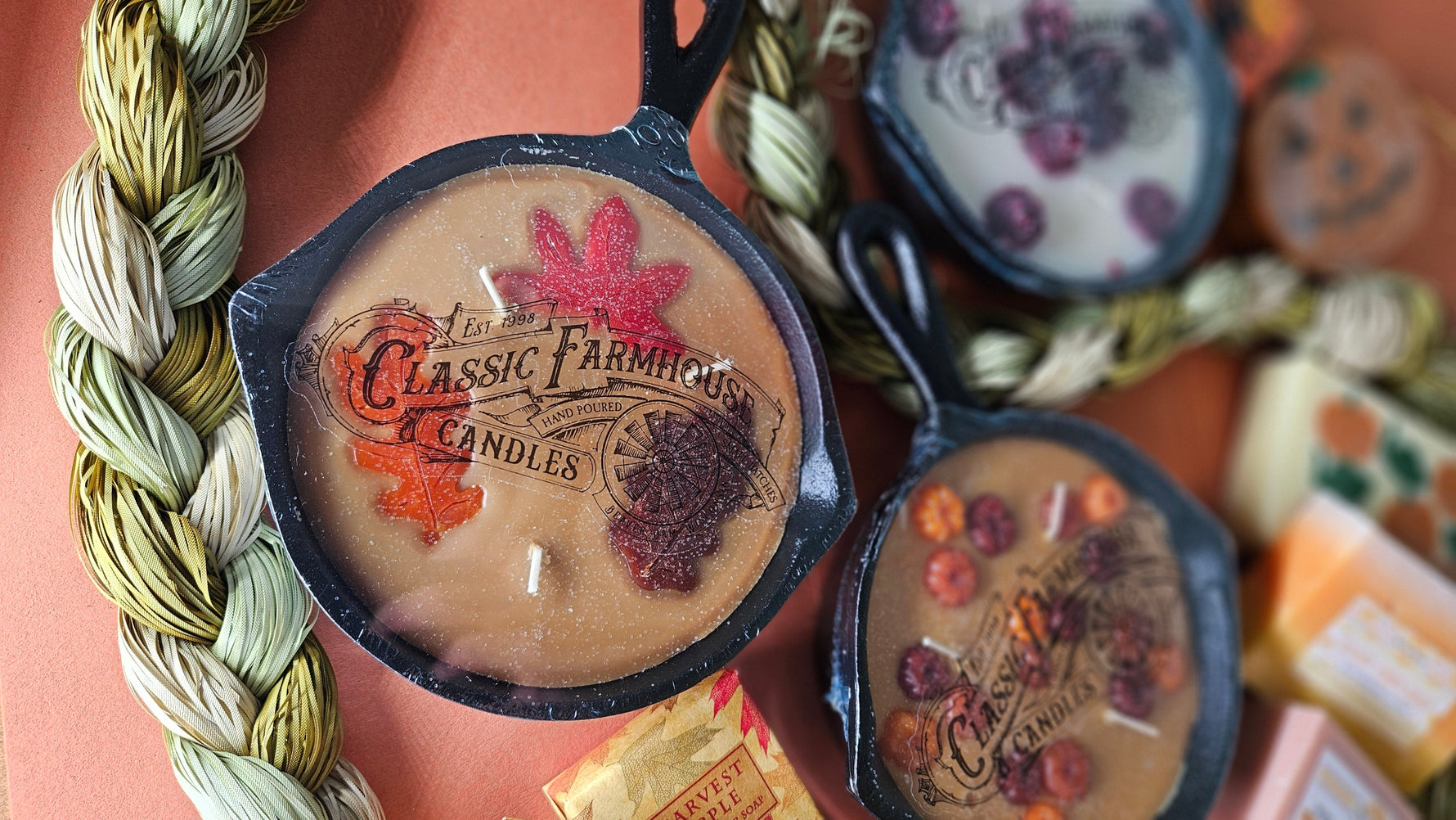 Collection of 'Classic Farmhouse Candles' with decorative labels on a textured surface.