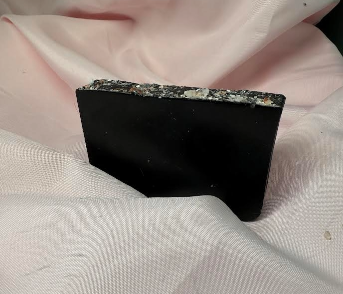 Slice of Primal Elements Charcoal Bamboo bar soap, jet black soap with Himalayan Salt and Rocks covering the top. 