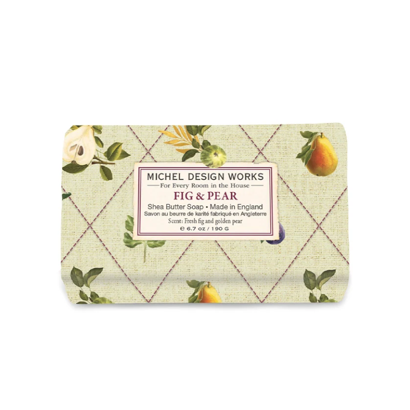 Michel Design Works Fig & Pear Shea Butter Soap in a rectangular wrapped bar with a light beige patterned cover, featuring green leaves, yellow figs, and a central white label with black text.