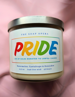 candle with bold pride letters watermelon cantaloupe and honeydew scented every candle donates sales to lgbtq causes