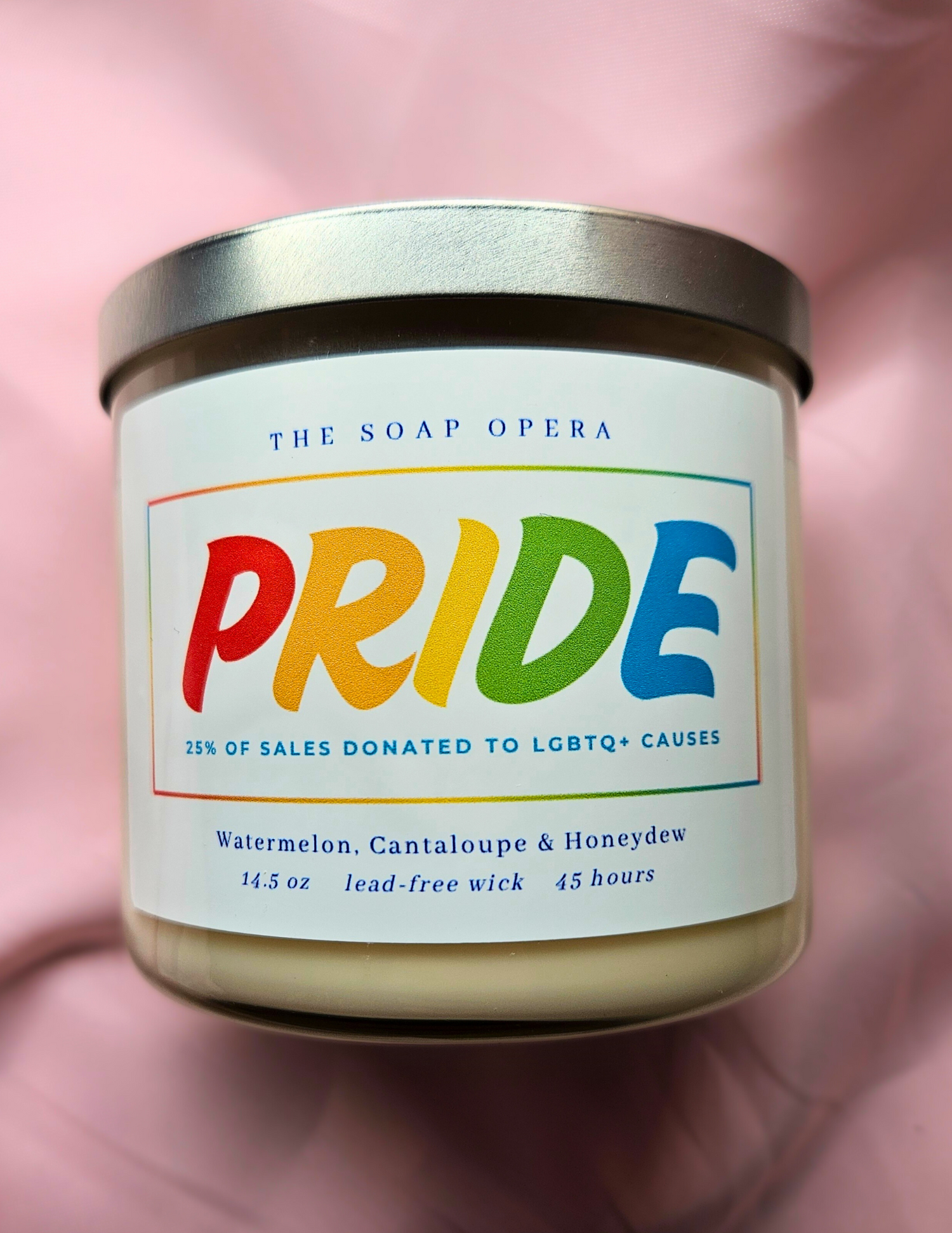 candle with bold pride letters watermelon cantaloupe and honeydew scented every candle donates sales to lgbtq causes