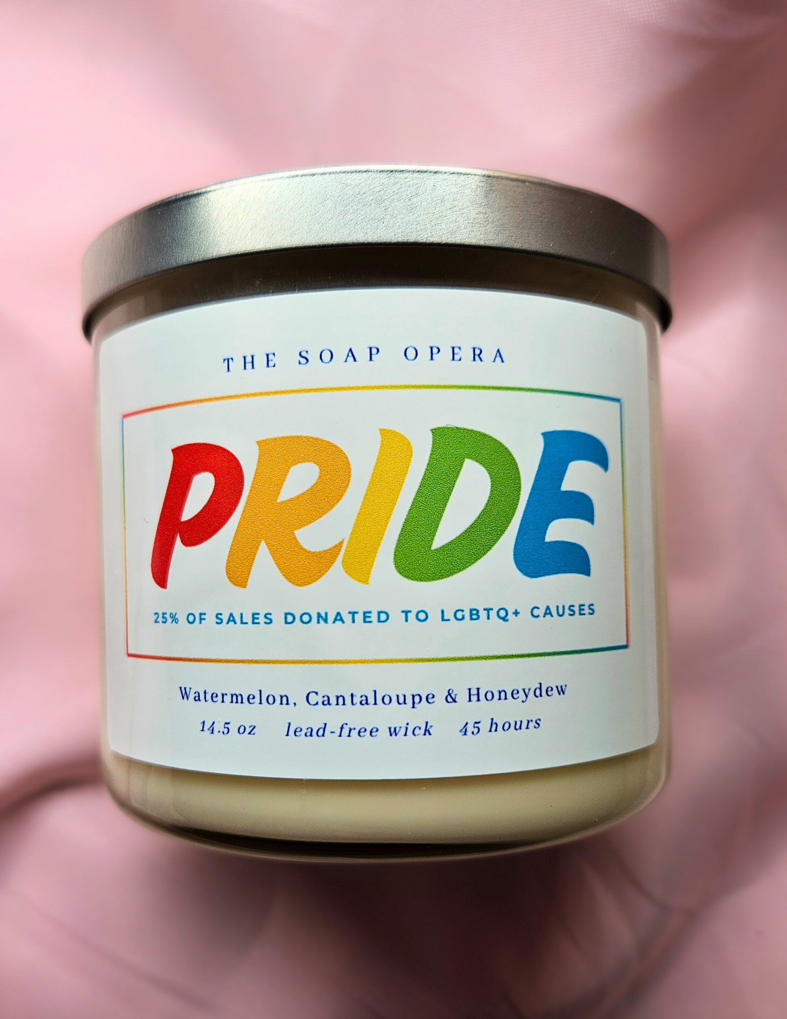 candle with bold pride letters watermelon cantaloupe and honeydew scented every candle donates sales to lgbtq causes