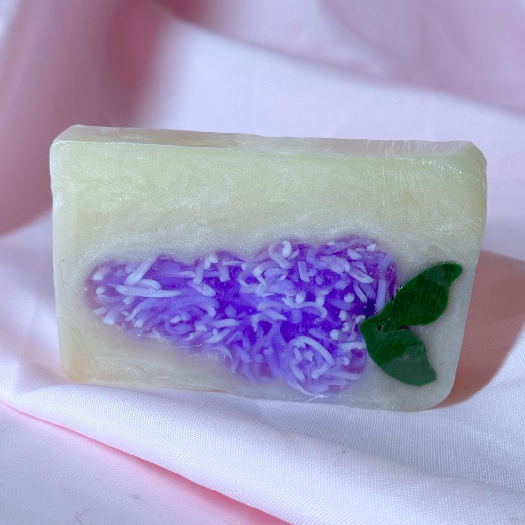 Bright purple lilac bar soap body wash soap on pink fabric backdrop