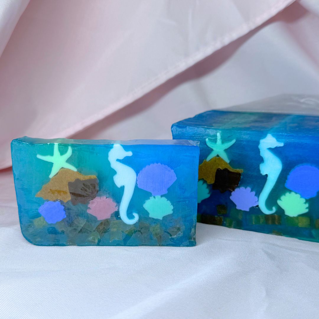 Blue vegetable glycerin decorative soap with underwater scene seahorse shells starfish coral design on a white background with loaf