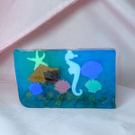 Blue vegetable glycerin decorative soap with underwater scene seahorse shells starfish coral design on a white background