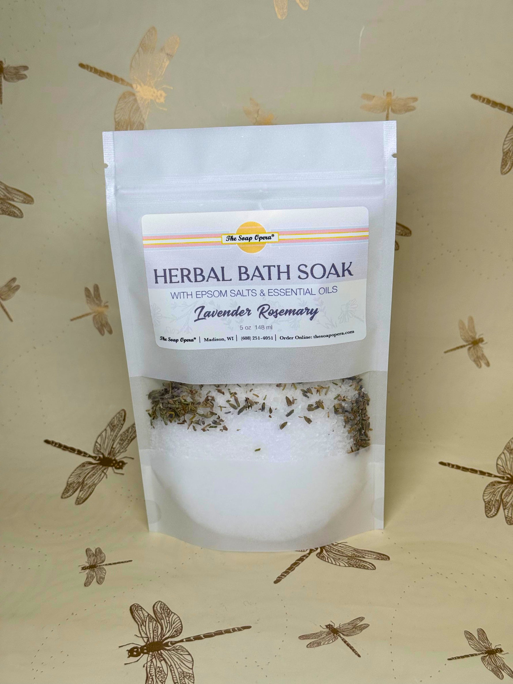 Herbal bath soak package with lavender and rosemary on a beige background with dragonfly designs.