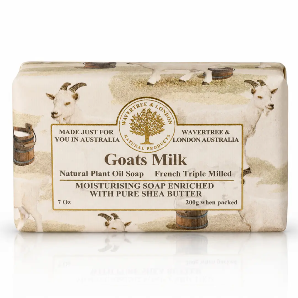 A rectangular bar of Wavertree & London Goats Milk Natural Plant Oil Soap, wrapped in a cream-colored paper sleeve decorated with illustrations of white goats and rustic barrels, set against a plain white background with a soft reflection.