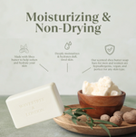 A bar of Wavytree & London moisturizing and non-drying shea butter soap is shown in a styled product shot with a small wooden bowl of whipped shea butter, whole nutmegs, and green leaves on a wooden tray. The background is a soft light gray with text highlighting product benefits.