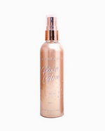 A tall spray bottle with a shimmery tan color. Holographic rainbow text reads "Pixie Glow".