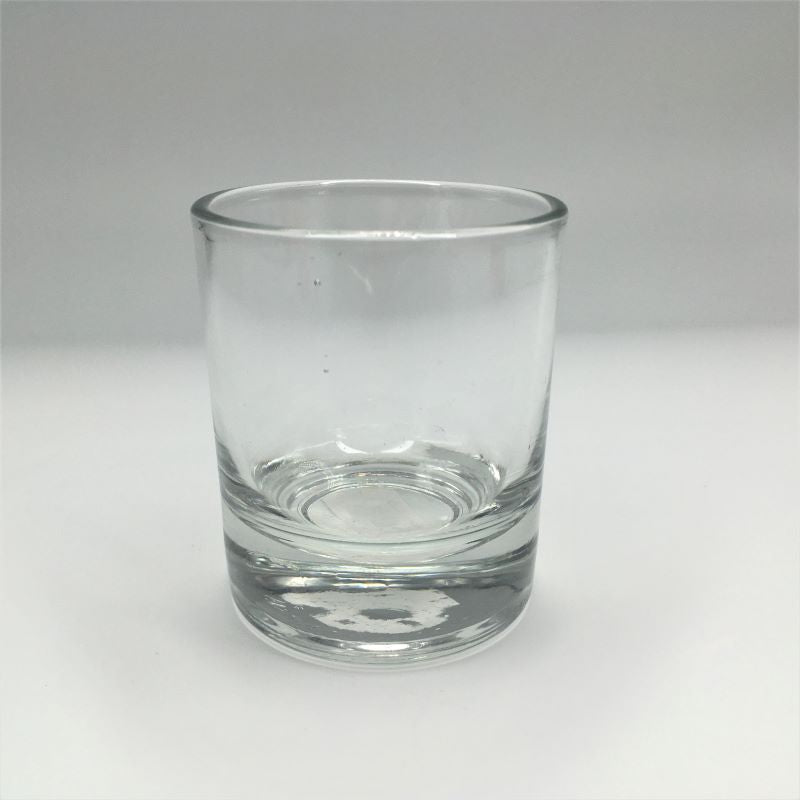 A clear glass votive candle holder with a heavy bottom.