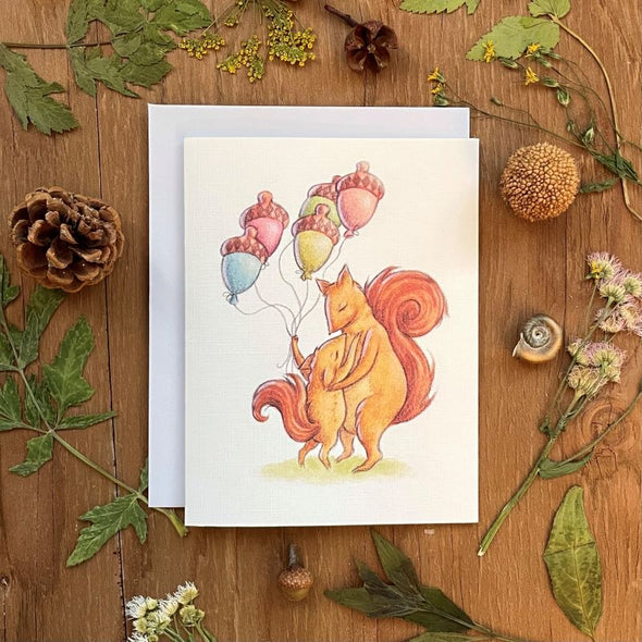 aubree sue art greeting card birthday squirrels, big squirrel with little squirrel hugging, holding multicolor acorn shaped balloons, blank inside, with white envelope