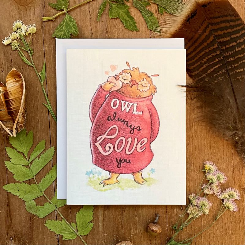 aubree sue art greeting card with watercolor illustration of owl with sweater that says owl always love you. they are also holding a heart. great for mother's day, valentine's day or just because. blank inside with envelope.